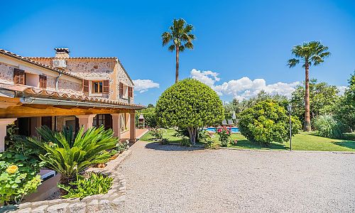 Aussenbereich Rasen Pool Terrasse Palmen Gartenmoebel Bergblick