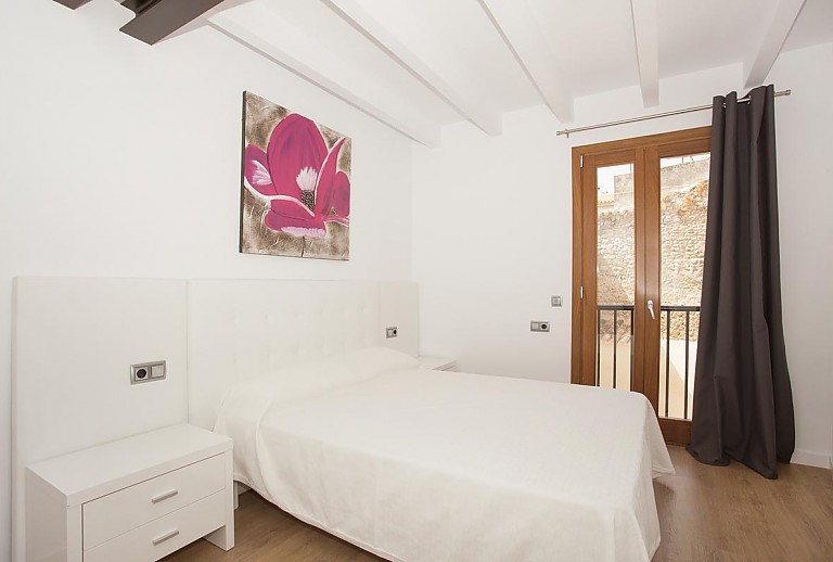 Schlafzimmer mit großen Fenstern und Doppelbett
