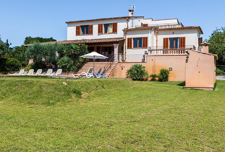 Rasen mit Pool und Finca im Hintergrund