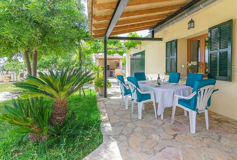 Terrasse mit Vordach und Esstisch im Schatten