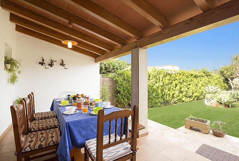 Terrasse mit Vordach und Gartenmöbeln