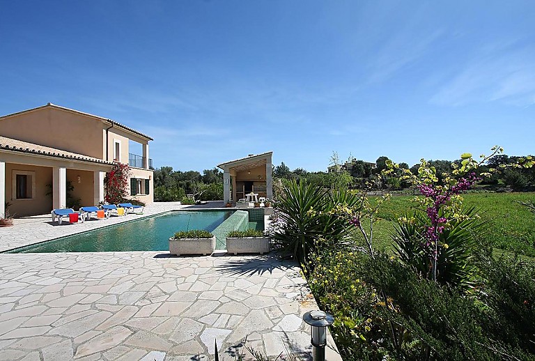 Poolbereich vor der Finca mit Sonnenliegen und Rasen