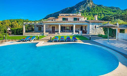 Poolbereich vor der Finca mit Sonnenliegen und Rasen