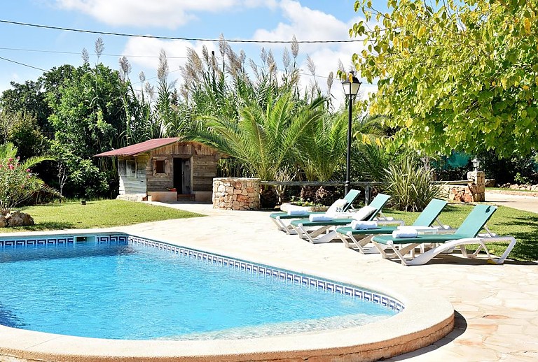 Garten mit Sonnenliegen am Poolbereich