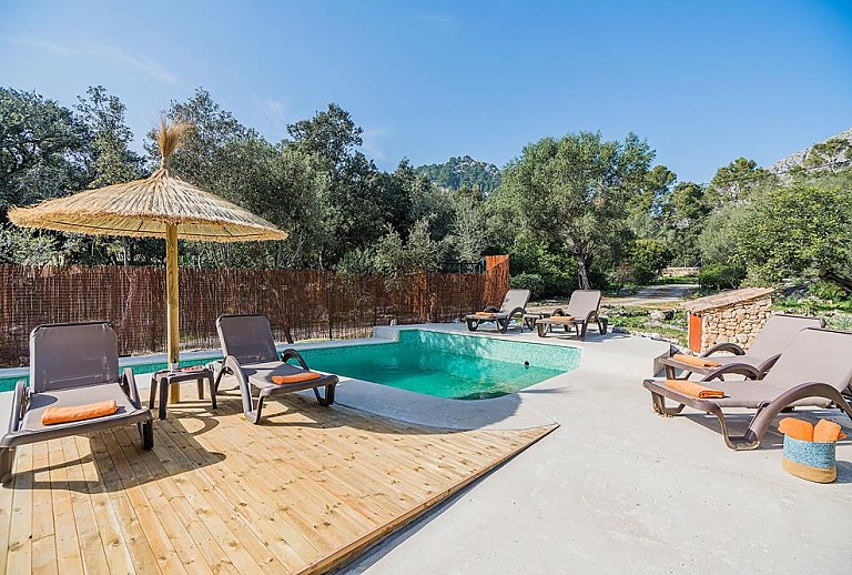 Pool mit Sonnenschirm und Sonnenliegen