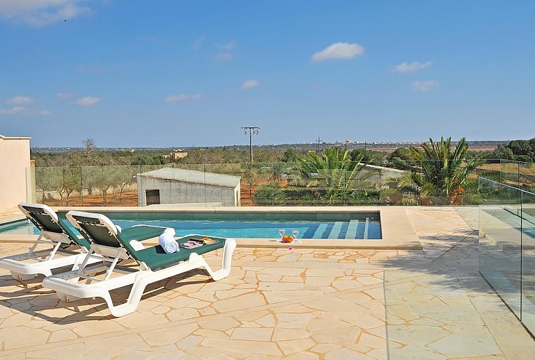 Poolbereich mit Sonnenliegen vor der Finca