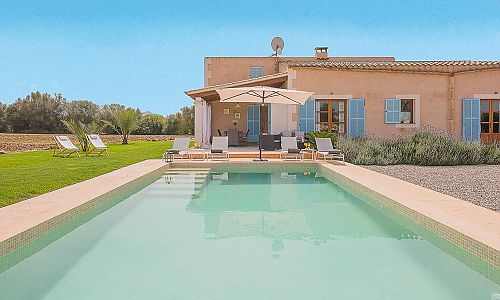 Poolbereich vor der Finca mit Sonnenschirm und Poolliegen