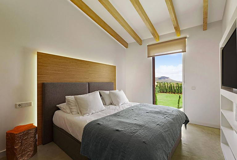Schlafzimmer mit Doppelbett und Fernseher