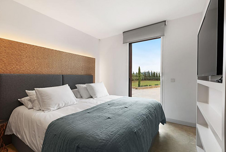 Schlafzimmer mit Doppelbett und Fernseher