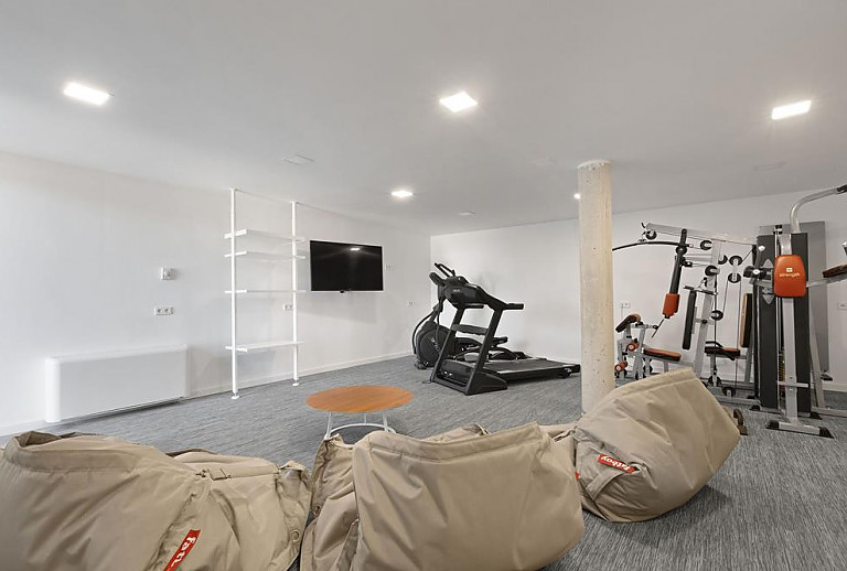 Fitnessraum mit Geräten und Fernseher 