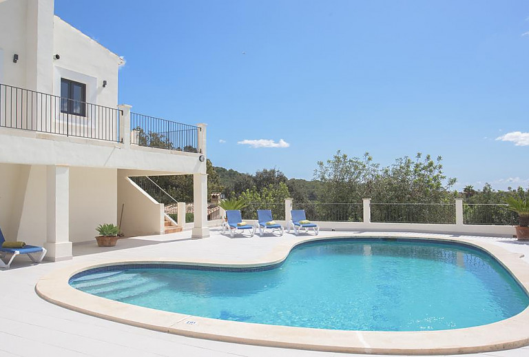 Pool mit Liegestühlen vor dem Ferienhaus