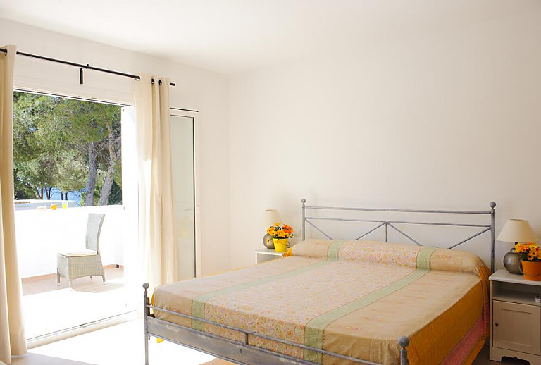 Doppelbett im Schlafzimmer und Zugang zur Terrasse