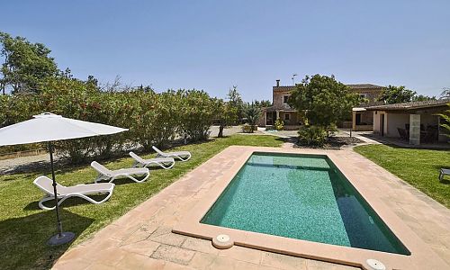 Pool mit Sonnenliegen vor der Finca