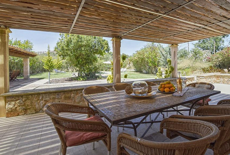 Überdachte Terrasse mit Esstisch und Blick in den Garten