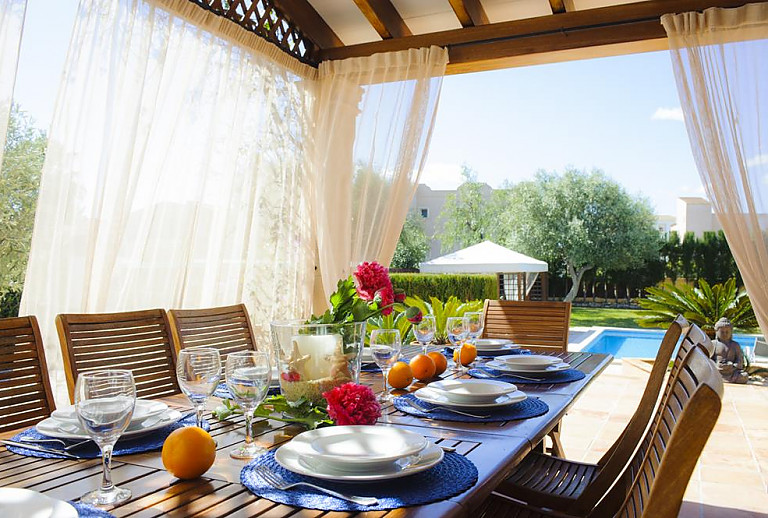 Terrasse mit Esstisch und Blick auf den Pool