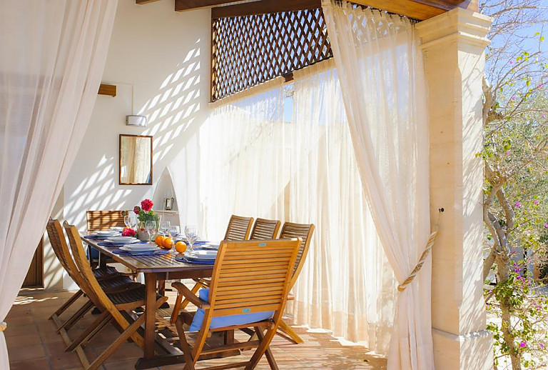 Terrasse mit Esstisch und Sonnenschutz