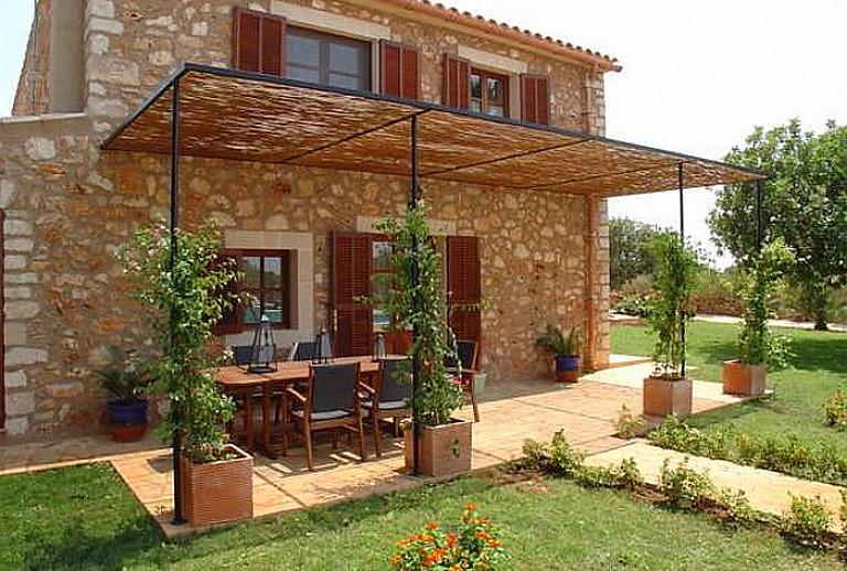 Terrasse am Haus mit Rasen und Pflanzen