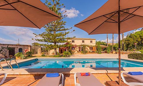 Poolbereich mit Sonnenschirm und Poolliegen