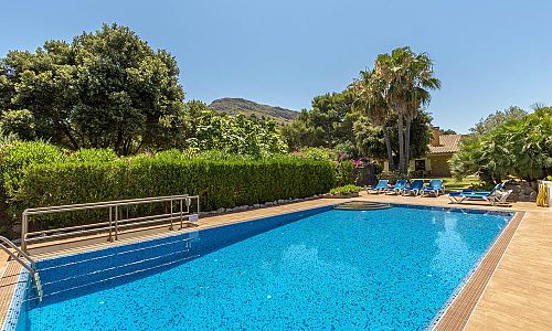 Pool mit Sonnenliegen vor dem Ferienhaus