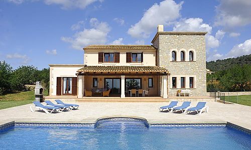 Pool mit Sonnenliegen vor dem Ferienhaus