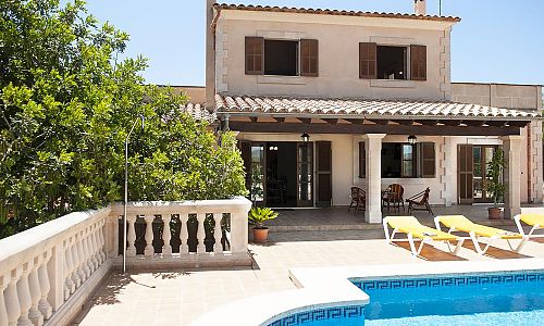 Pool mit Sonnenliegen vor dem Ferienhaus