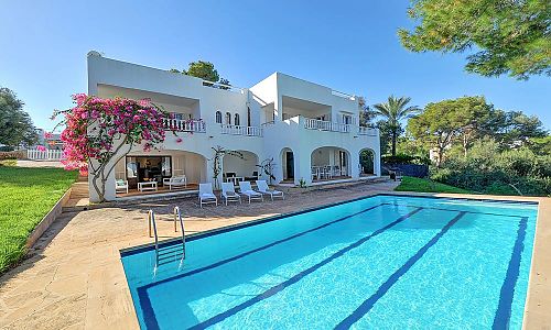 Pool mit Sonnenliegen vor dem Ferienhaus