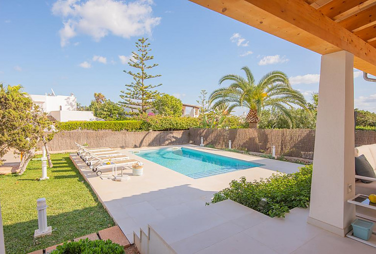 Außenbereich mit Pool und Sonnenliegen