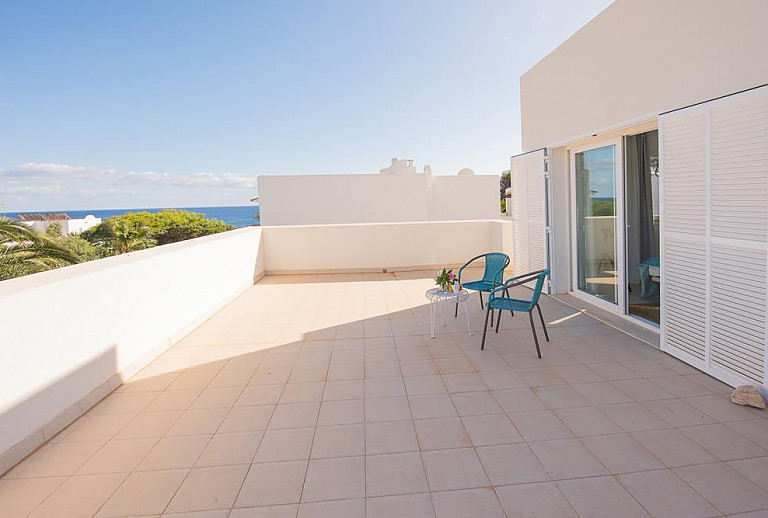 Terrasse mit Meerblick und Gartenmöbeln