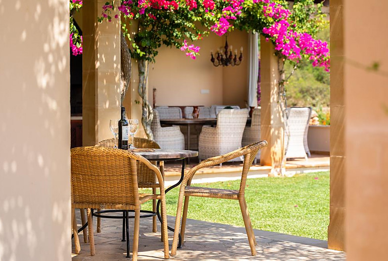 Terrasse mit Korbstühlen und Schatten