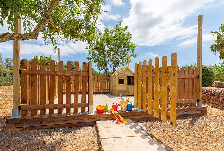 Eingezäunter Spielplatz mit Baum