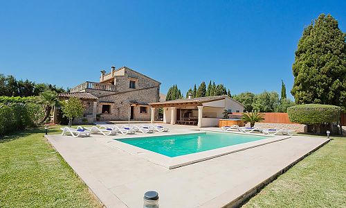 Poolterrasse mit Sonnenliegen und Essbereich vor der Finca
