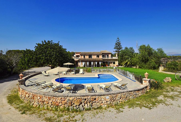 Poolterrasse und Sonnenliegen vor der Finca