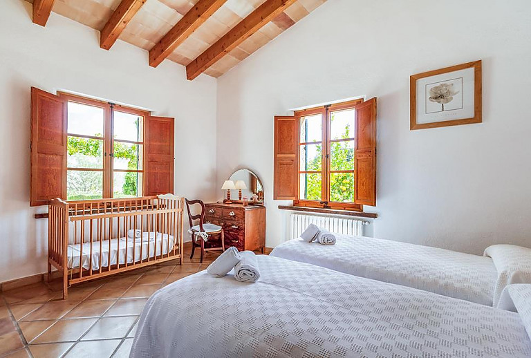 Schlafzimmer mit Einzelbetten und Babybett