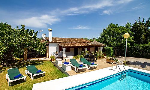 Pool und Sonnenliegen auf dem Rasen vor der Finca