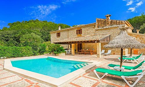 Poolbereich mit Sonnenliegen und Sonnenschirm