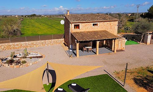 Außenbereich mit Sonnenliegen und Rasen vor der Finca
