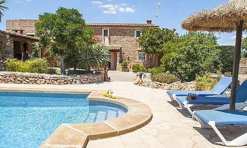 Poolbereich mit Liegen und Sonnenschirm vor der Finca