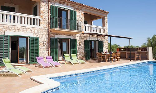 Pool mit Sonnenliegen auf der Terrasse vor der Finca