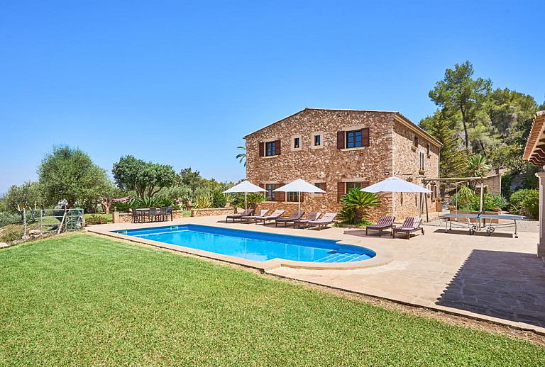 Garten mit Rasen und Sonnenliegen vor der Finca