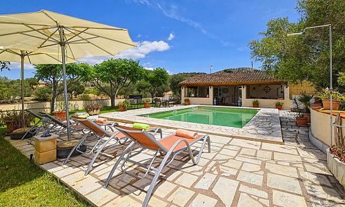 Pool mit Liegen und Sonnenschirm vor der Finca