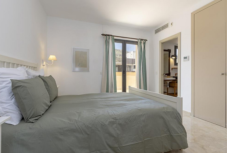Schlafzimmer mit Doppelbett und Badezimmer