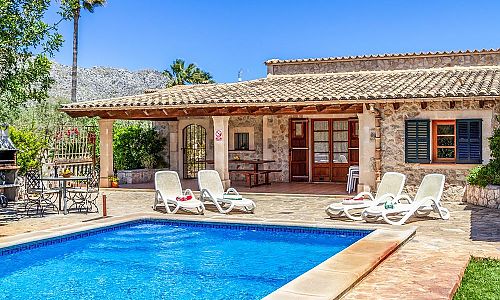 Pool mit Sonnenliegen vor der Finca