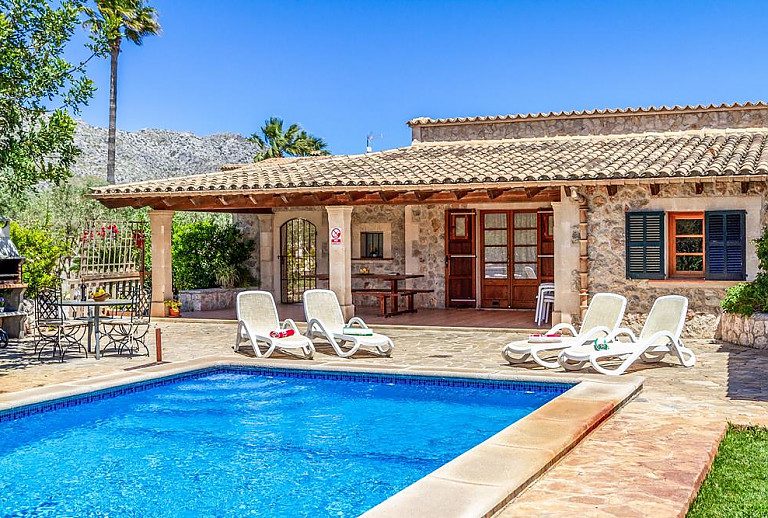 Pool mit Sonnenliegen vor der Finca