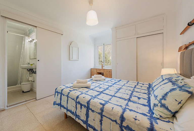 Schlafzimmer mit Doppelbett und Badezimmer