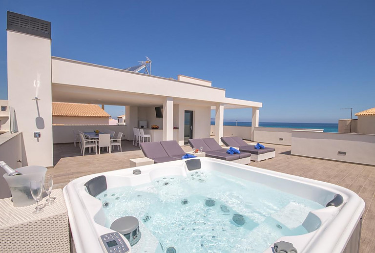 Whirlpool auf der Terrasse mit Poolliegen