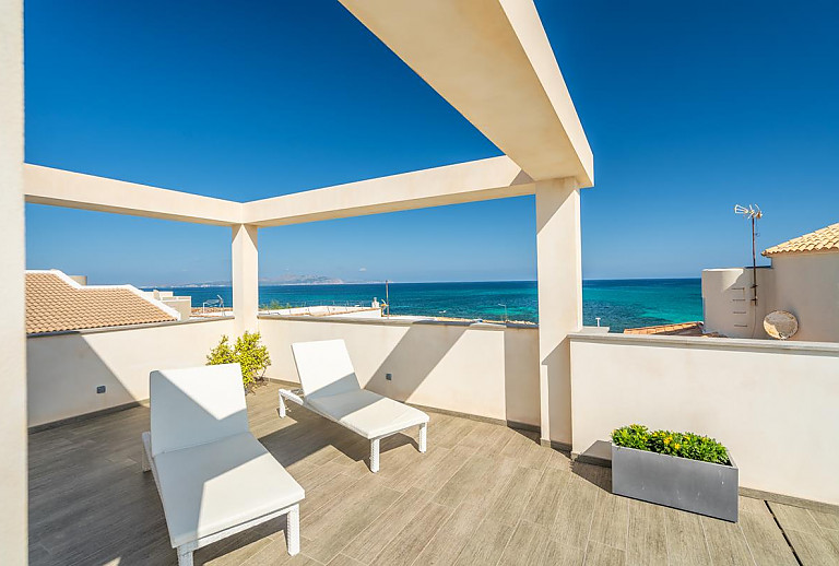 Terrasse mit Poolliegen und Meerblick