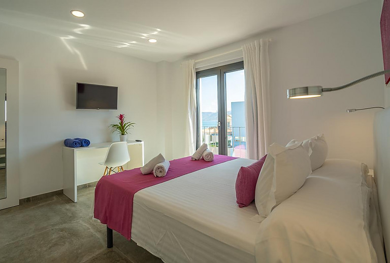 Schlafzimmer mit Doppelbett und Fernseher