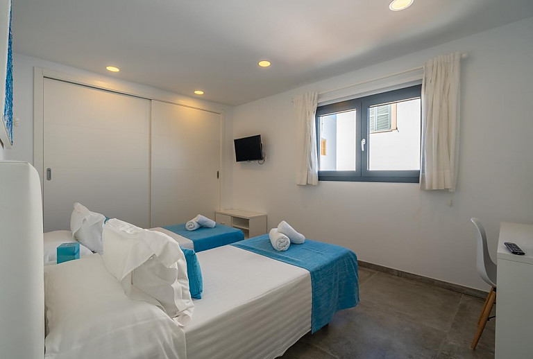 Schlafzimmer mit Einzelbetten und Fernseher