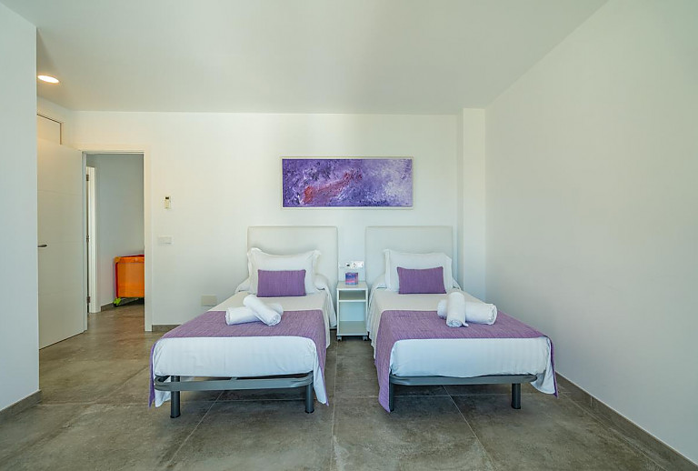 Schlafzimmer mit Einzelbetten und Wandbild