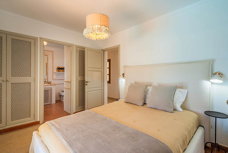 Schlafzimmer mit Doppelbett und Badezimmer